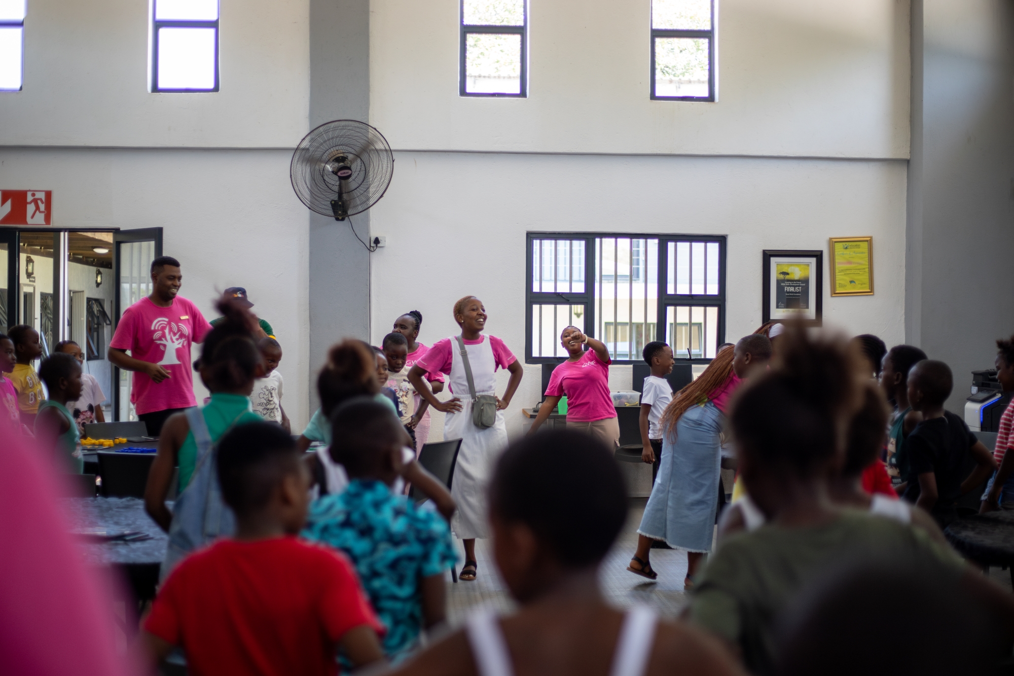 Marlin-Clark-rhino-africa-marketing-team-visit-at-gwf-41 A room filled with children and educators brims with energy as facilitators in pink shirts lead an animated activity, their enthusiasm reflected in the excited faces of the students.