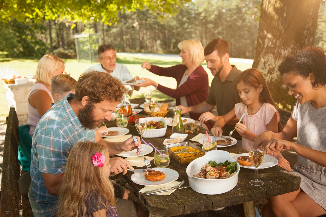 Family having barbecue meal at paved back yard. A family enjoying a meal of typical South African food