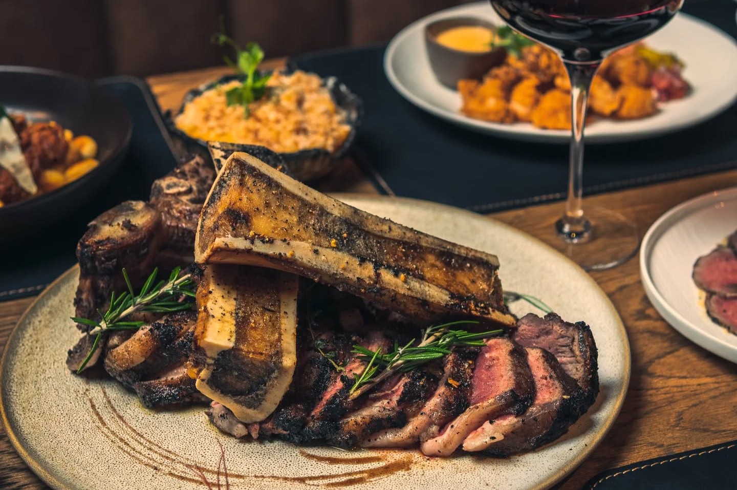 A restaurant table with sliced steak and complimentary dishes
